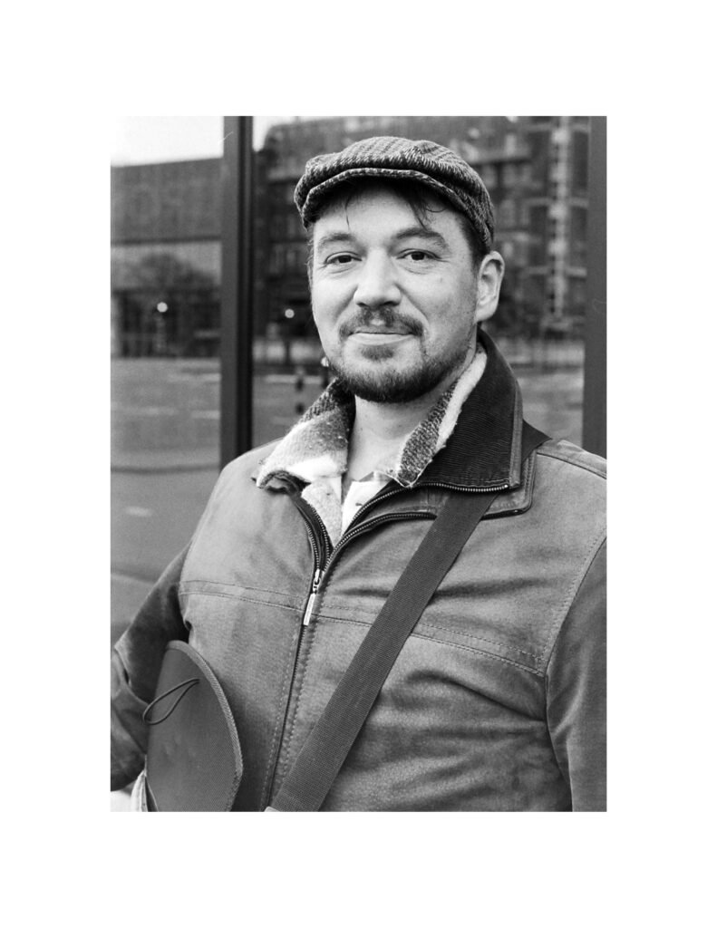 Black and white closeup of a smiling Bart